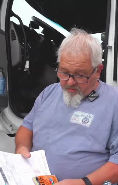 Rick reading the hazmat shipping papers at the cab with the orange Emergency Response Guidebook